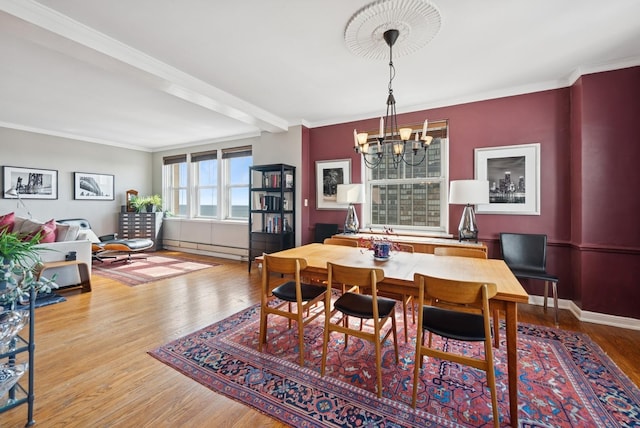 dining area with a chandelier, baseboards, ornamental molding, wood finished floors, and baseboard heating
