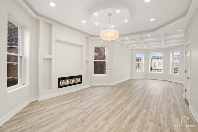 unfurnished living room with beamed ceiling, a chandelier, light hardwood / wood-style floors, and coffered ceiling