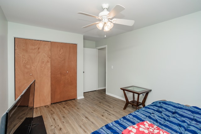 bedroom featuring ceiling fan, a closet, and light wood-type flooring