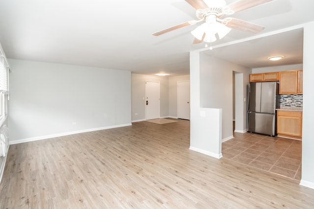 unfurnished living room featuring ceiling fan and light hardwood / wood-style floors