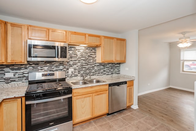 kitchen featuring decorative backsplash, sink, stainless steel appliances, and light hardwood / wood-style flooring