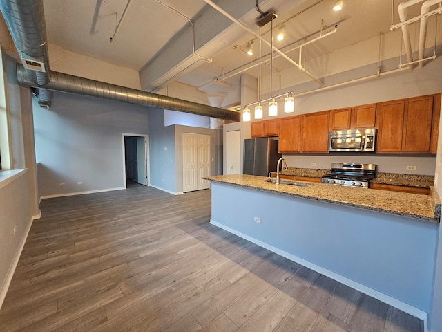 kitchen featuring appliances with stainless steel finishes, dark hardwood / wood-style floors, pendant lighting, and a high ceiling