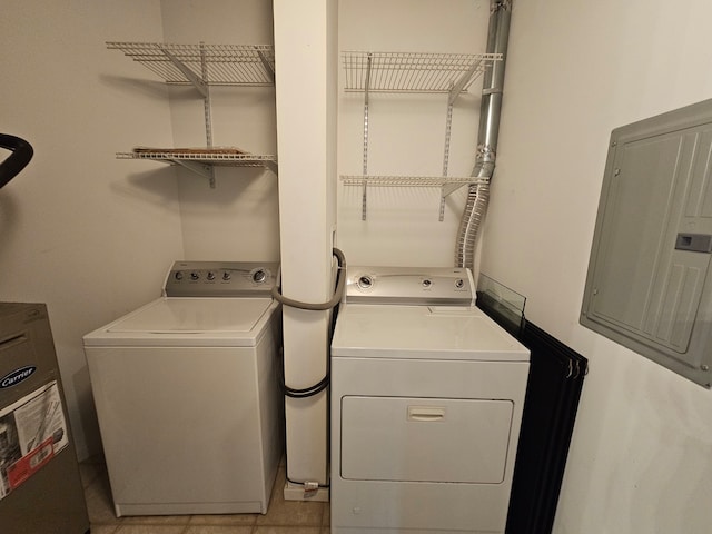 clothes washing area featuring separate washer and dryer, light tile patterned floors, electric panel, and water heater