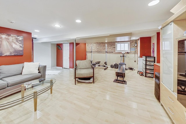 living room featuring light hardwood / wood-style flooring and brick wall