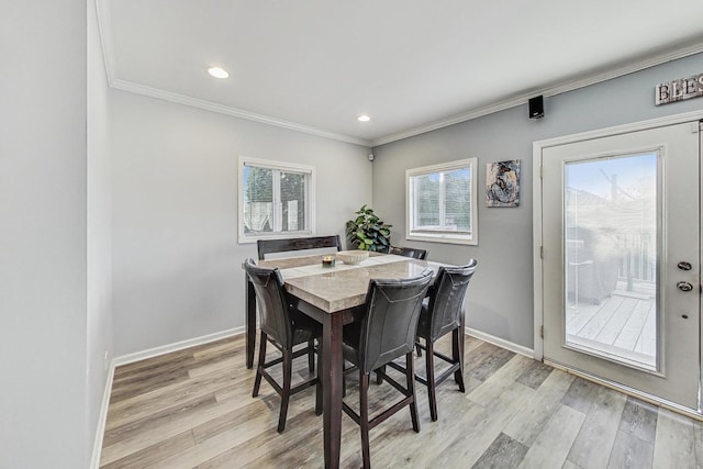 dining room featuring light hardwood / wood-style flooring and crown molding