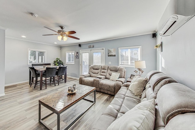 living room featuring a wall mounted AC, ceiling fan, crown molding, and light wood-type flooring