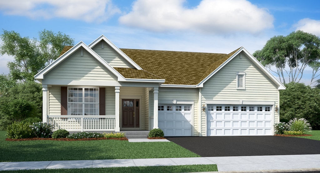 view of front of home featuring covered porch, a garage, and a front lawn