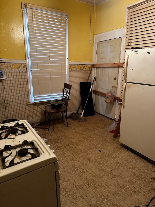 kitchen with white appliances and tile walls