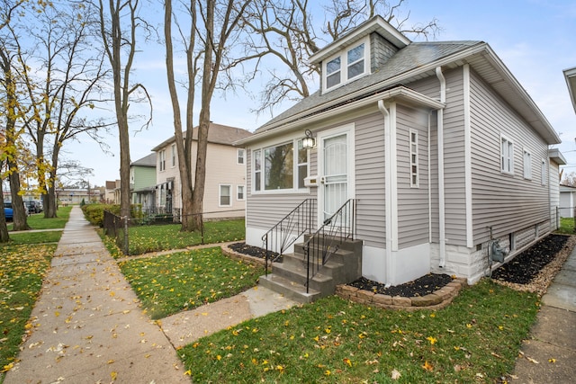 bungalow-style house featuring a front lawn