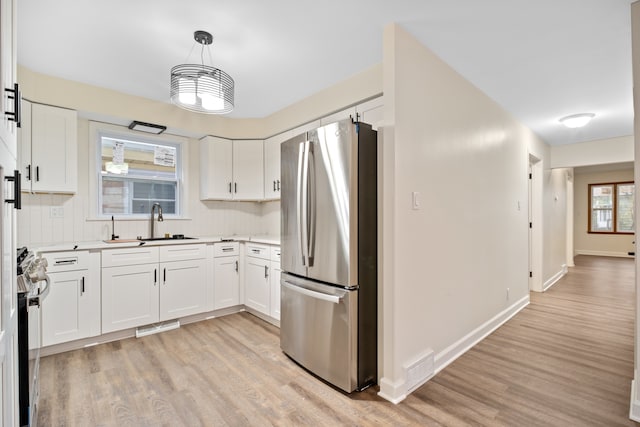 kitchen with white cabinets, appliances with stainless steel finishes, and light hardwood / wood-style floors