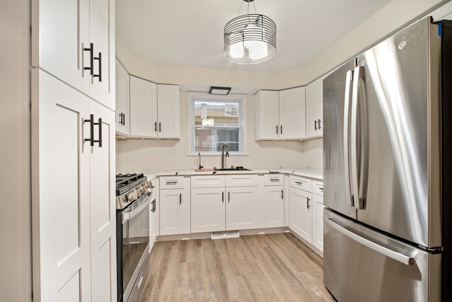 kitchen featuring white cabinets, pendant lighting, and stainless steel appliances