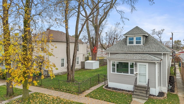 view of front facade with a front lawn and a storage unit