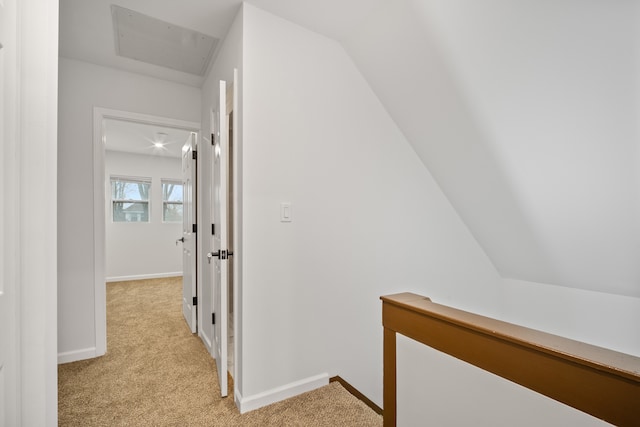 corridor with light colored carpet and lofted ceiling