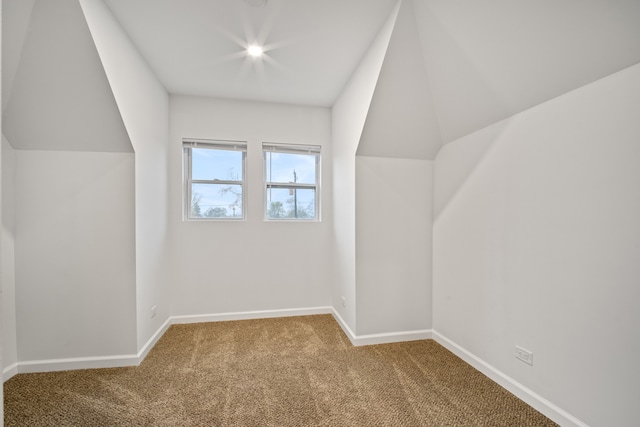 additional living space featuring carpet floors and vaulted ceiling