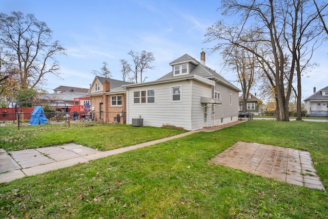 back of property featuring a lawn and cooling unit