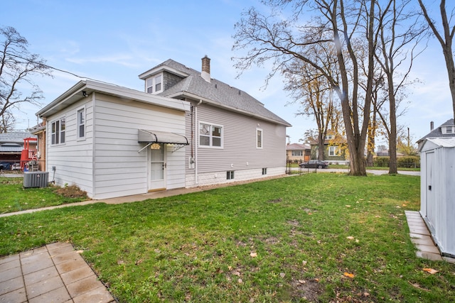 back of house with central AC and a lawn