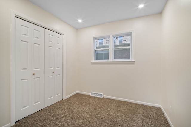 unfurnished bedroom featuring carpet and a closet