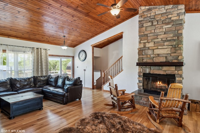 living room featuring wooden ceiling, a stone fireplace, light hardwood / wood-style flooring, vaulted ceiling, and ceiling fan