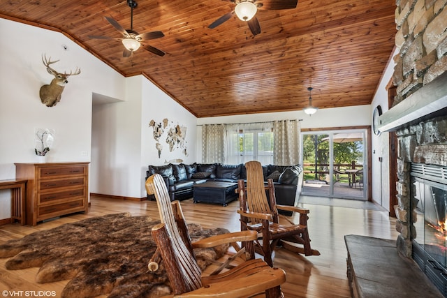 living room featuring wooden ceiling, a stone fireplace, light wood-type flooring, and vaulted ceiling