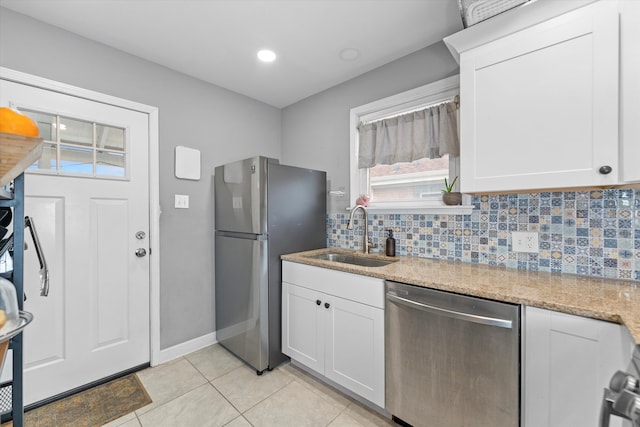 kitchen featuring sink, light tile patterned floors, decorative backsplash, white cabinets, and appliances with stainless steel finishes