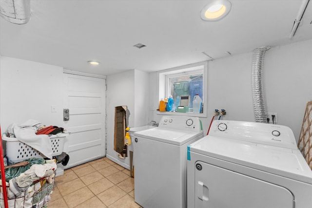 clothes washing area with separate washer and dryer and light tile patterned floors