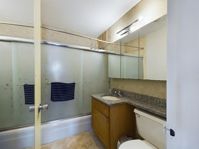 655 W Irving Park Rd Unit 1710, Chicago, IL 60613 - full bathroom with bath / shower combo with glass door, vanity, toilet, and decorative backsplash