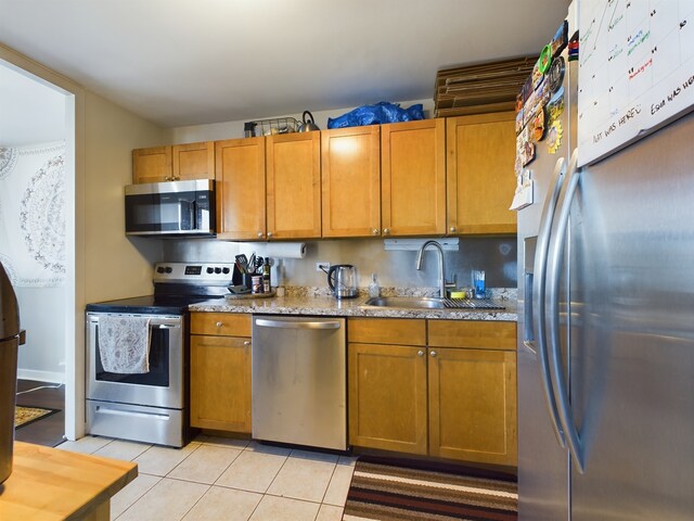 655 W Irving Park Rd Unit 1710, Chicago, IL 60613 - kitchen with appliances with stainless steel finishes, a sink, light tile patterned floors, brown cabinets, and light stone counters