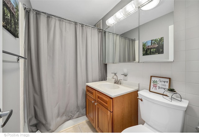 bathroom with vanity, tile patterned floors, toilet, tile walls, and walk in shower