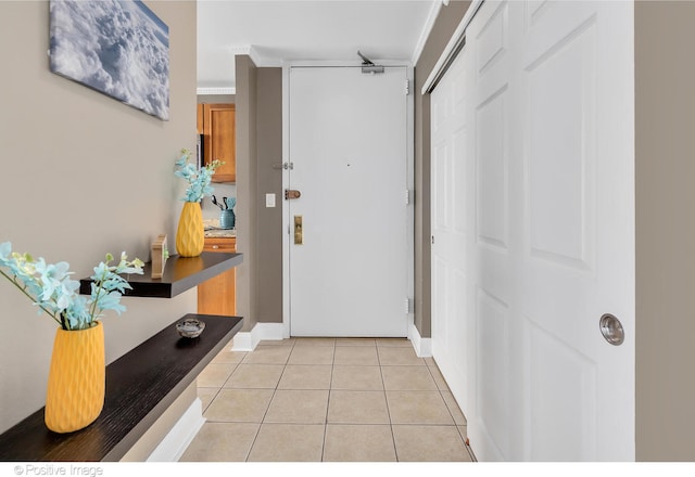 entrance foyer featuring light tile patterned floors and ornamental molding