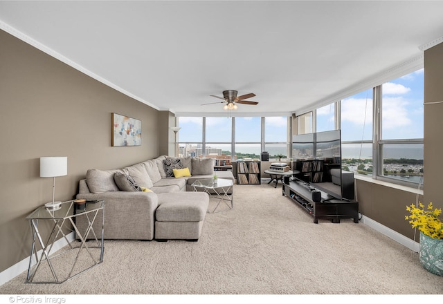 living room with carpet, expansive windows, ceiling fan, and ornamental molding