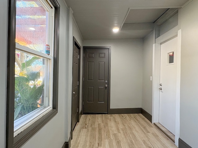 hallway with a healthy amount of sunlight and light hardwood / wood-style floors