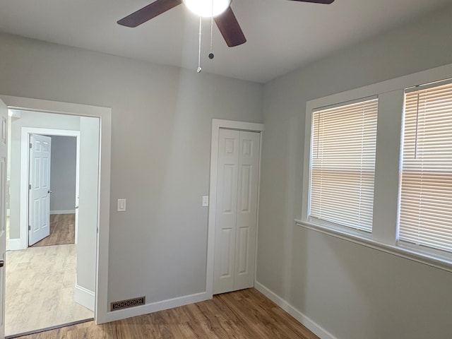 unfurnished bedroom featuring a closet, ceiling fan, and light hardwood / wood-style flooring