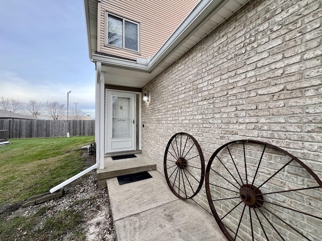 view of exterior entry with a lawn