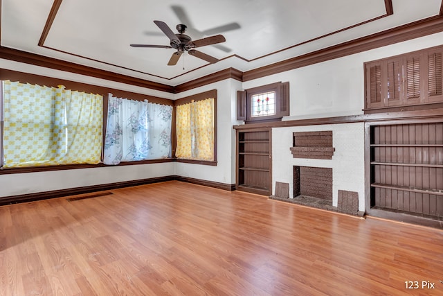 unfurnished living room with ceiling fan, light hardwood / wood-style floors, crown molding, and a fireplace