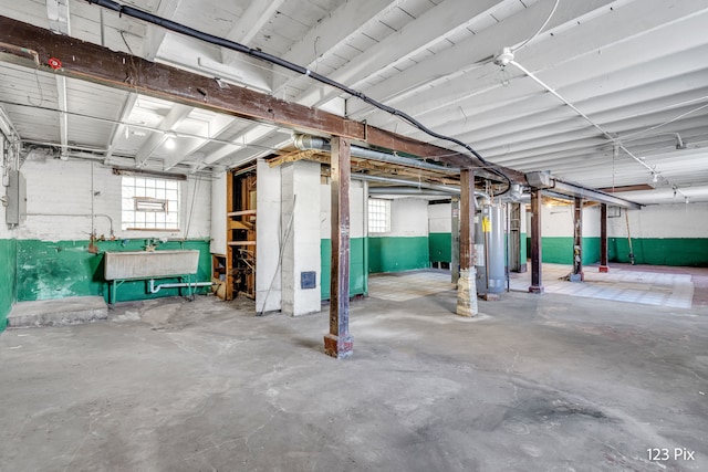 basement featuring gas water heater and sink