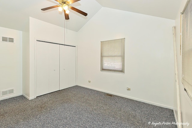 unfurnished bedroom featuring dark colored carpet, ceiling fan, lofted ceiling, and a closet