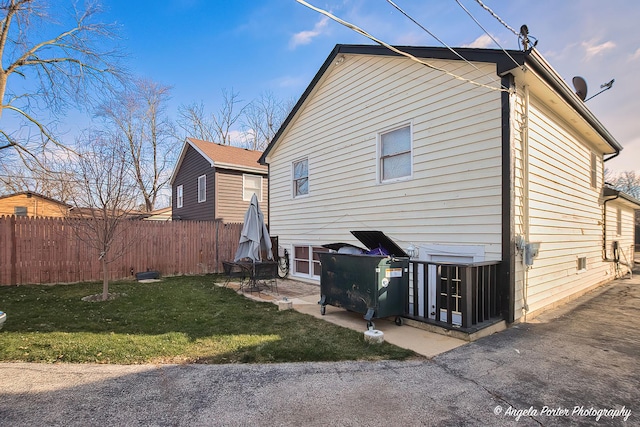 rear view of house featuring a lawn and a patio