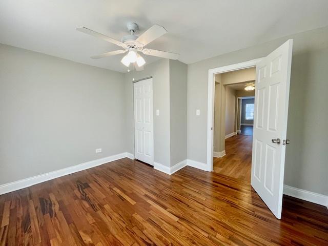 unfurnished bedroom with dark hardwood / wood-style flooring and ceiling fan