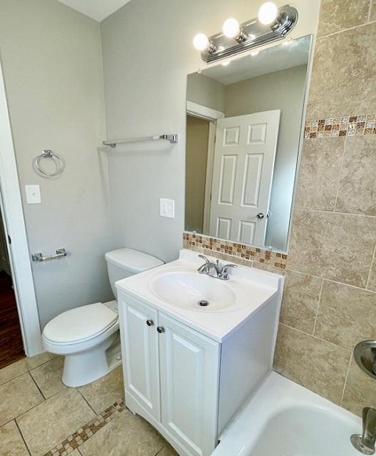 bathroom featuring vanity, toilet, and a bathing tub