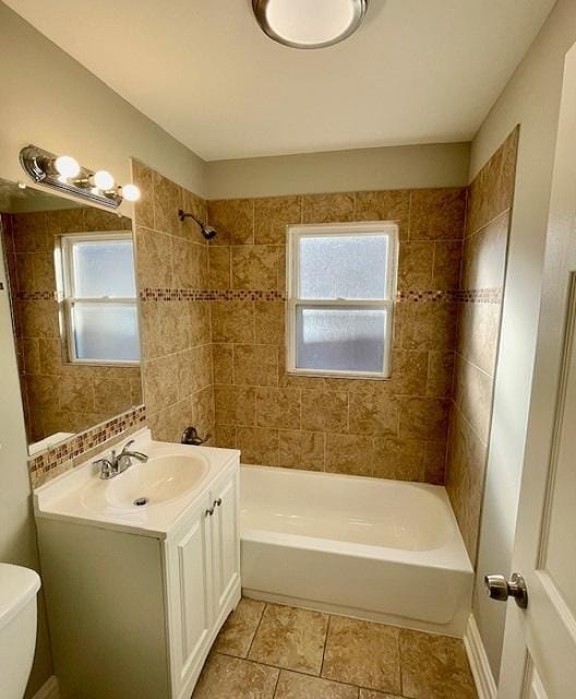 full bathroom featuring vanity, tiled shower / bath combo, tile patterned floors, and toilet