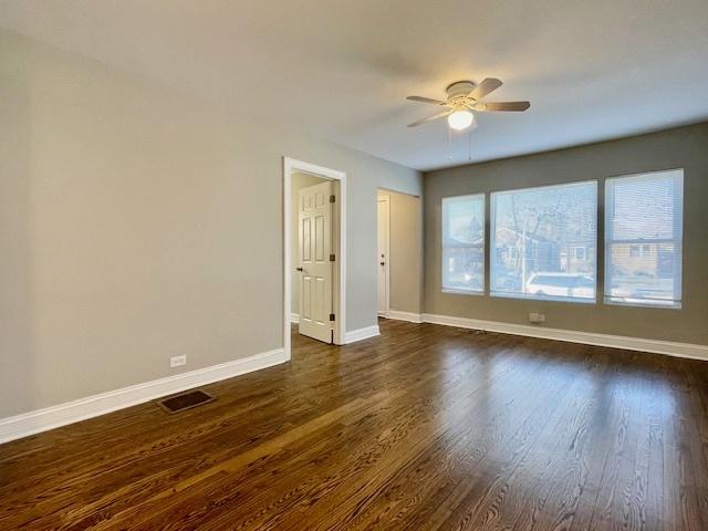 empty room with dark hardwood / wood-style flooring and ceiling fan