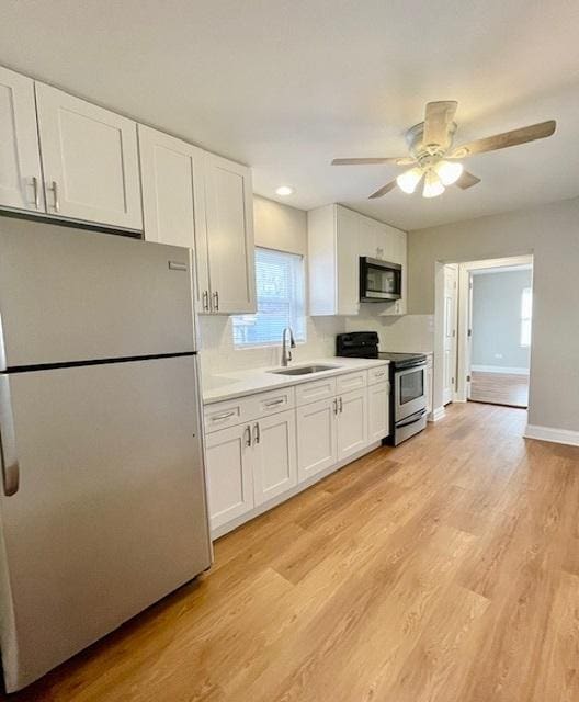 kitchen featuring sink, light hardwood / wood-style flooring, white cabinets, and appliances with stainless steel finishes