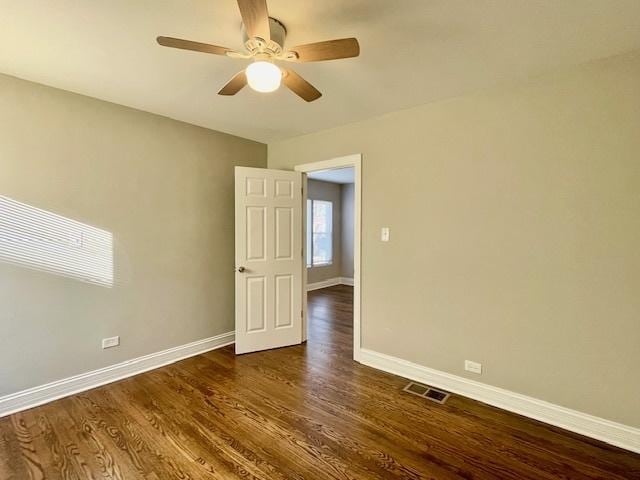 empty room featuring dark wood-type flooring and ceiling fan