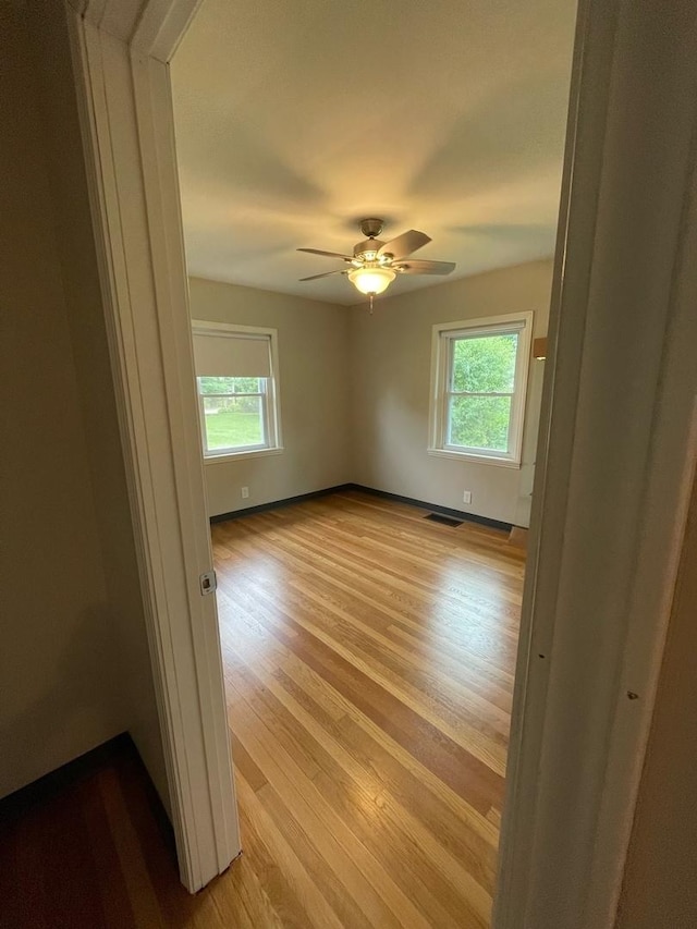 spare room featuring ceiling fan and light wood-type flooring