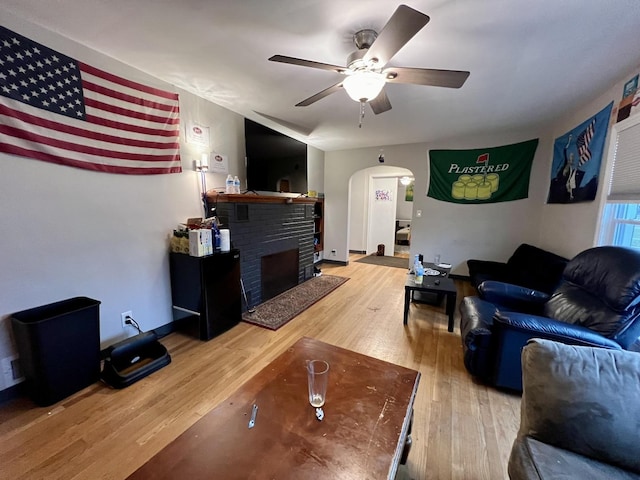 living room with a fireplace, ceiling fan, and hardwood / wood-style floors