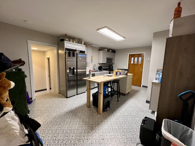 kitchen featuring stainless steel appliances, white cabinetry, and sink