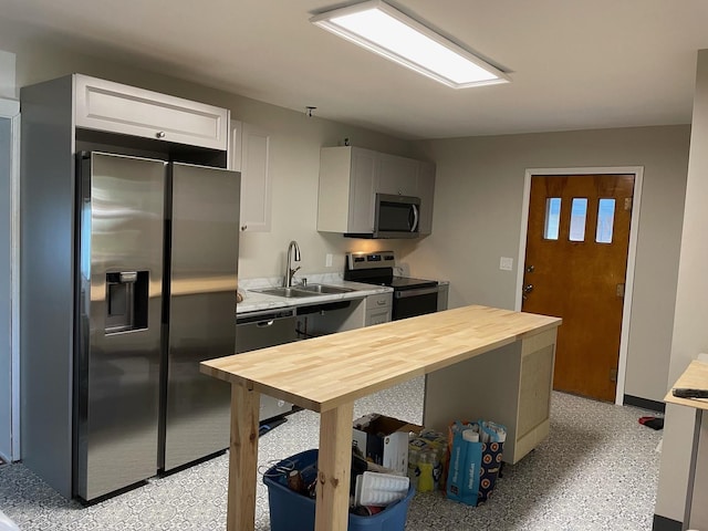 kitchen featuring gray cabinets, butcher block counters, sink, and appliances with stainless steel finishes