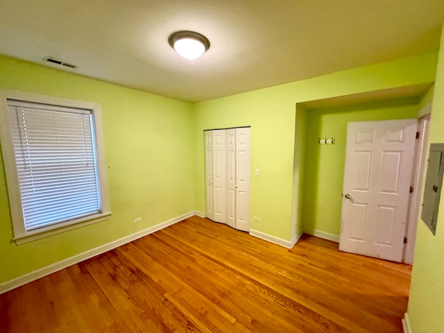 unfurnished bedroom featuring light wood-type flooring and a closet