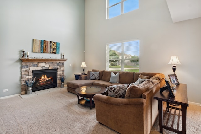 carpeted living room featuring a fireplace and a high ceiling