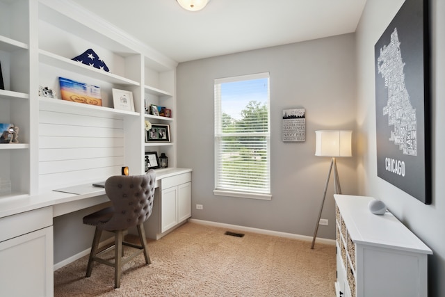 office space with light colored carpet and built in desk